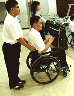 보조자가 휠체어를 잡고 있는 모습