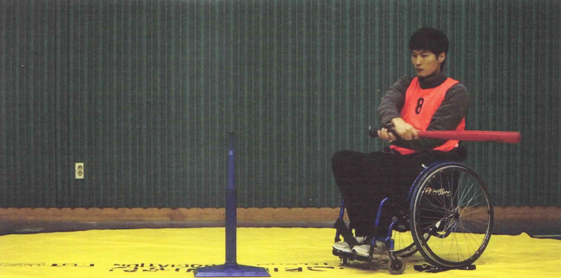 스트라이크 사진(휠체어에 앉아 배트를 잡고 있는 남자와 공이 없는 배팅티)